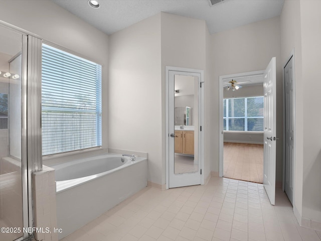 bathroom with tile patterned flooring, vanity, independent shower and bath, and ceiling fan