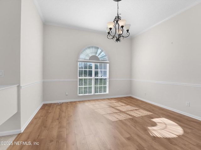 unfurnished room featuring hardwood / wood-style flooring, crown molding, and a notable chandelier