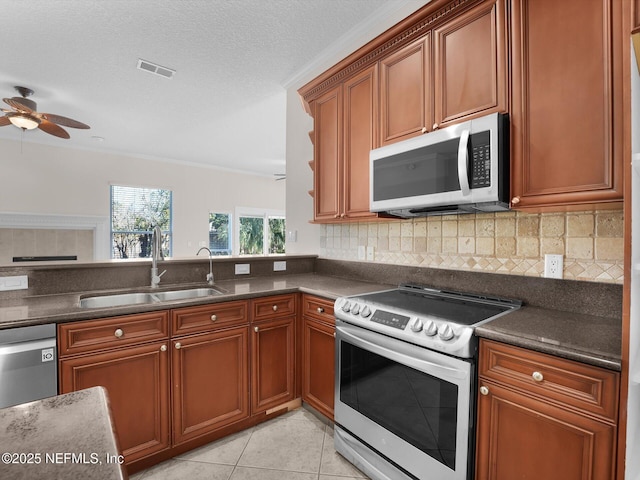 kitchen featuring sink, light tile patterned floors, ceiling fan, stainless steel appliances, and decorative backsplash