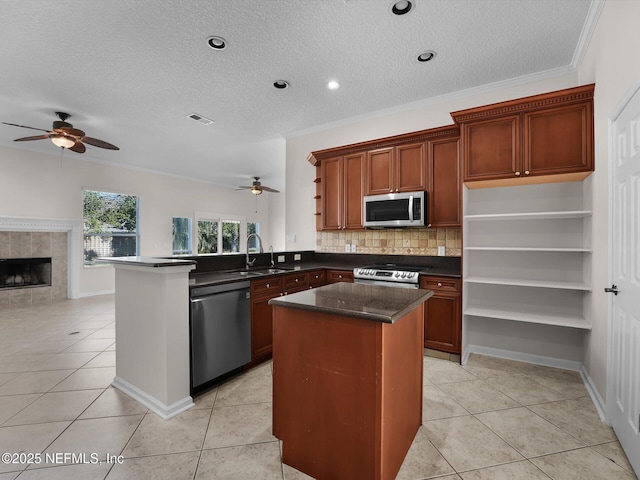 kitchen with sink, light tile patterned floors, kitchen peninsula, and appliances with stainless steel finishes