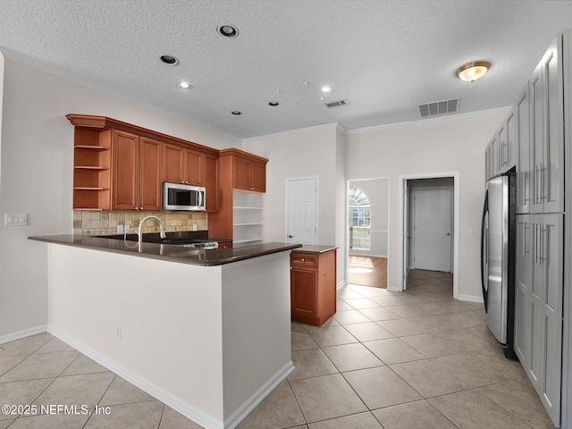 kitchen featuring crown molding, appliances with stainless steel finishes, light tile patterned floors, and kitchen peninsula