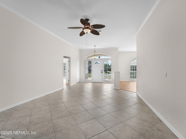 spare room with ceiling fan, ornamental molding, a textured ceiling, and light tile patterned floors