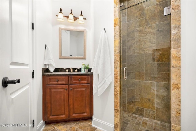 bathroom featuring a stall shower, stone finish flooring, and vanity