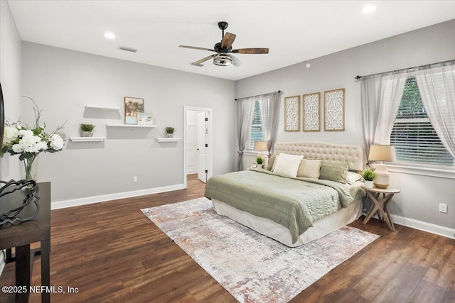 bedroom with visible vents, dark wood finished floors, baseboards, and multiple windows