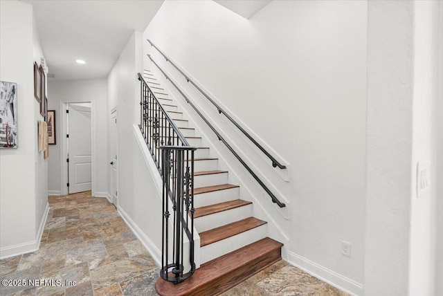 stairs with recessed lighting, stone finish floor, and baseboards