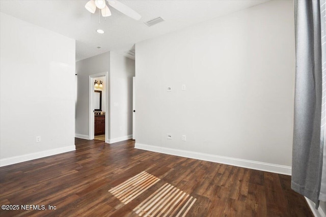 unfurnished room featuring dark wood-type flooring, visible vents, baseboards, and a ceiling fan