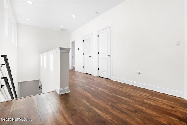 unfurnished room featuring baseboards, dark wood-style flooring, and recessed lighting