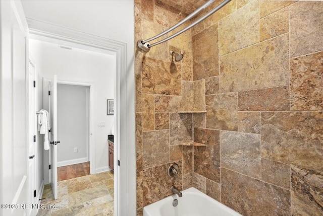 bathroom featuring stone finish floor and tub / shower combination