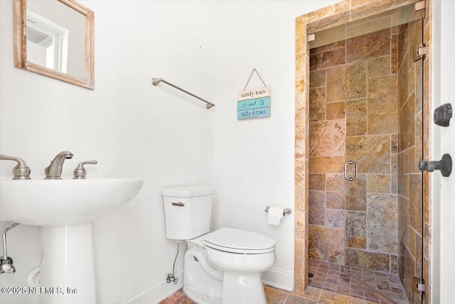 bathroom featuring toilet and a shower with shower door