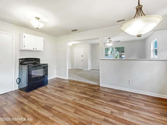 kitchen featuring ceiling fan, light wood-type flooring, hanging light fixtures, white cabinets, and black range with electric stovetop