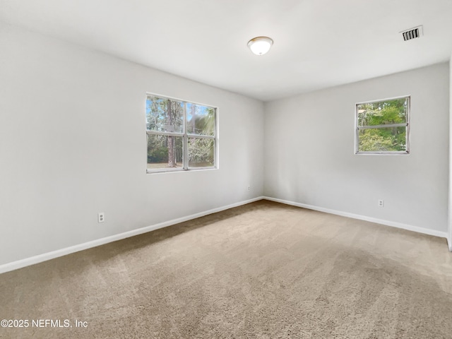 carpeted spare room featuring plenty of natural light