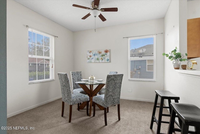 dining space featuring ceiling fan and light colored carpet