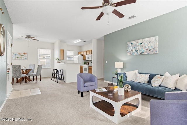 carpeted living room with ceiling fan