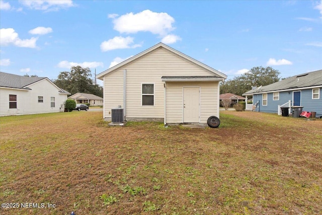 rear view of house with a yard and central AC