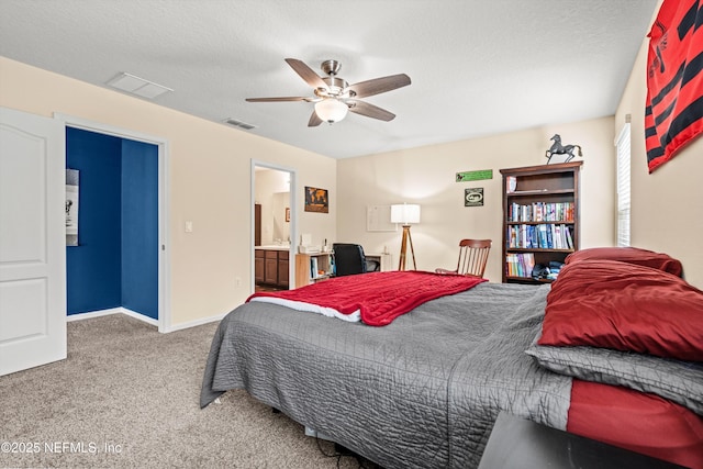 carpeted bedroom featuring ceiling fan, ensuite bath, and a textured ceiling