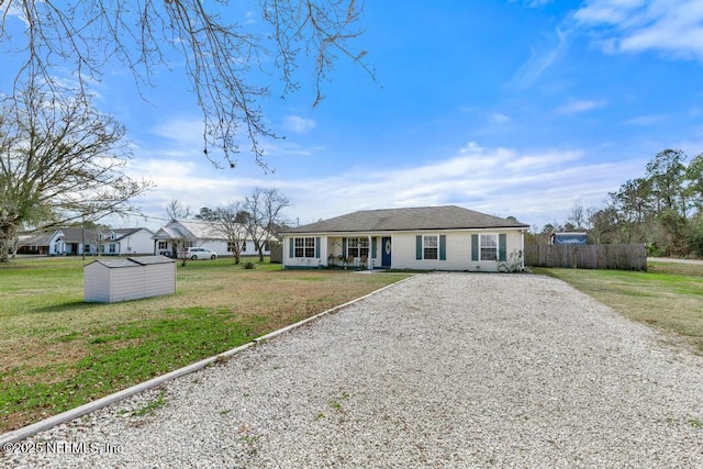 ranch-style home featuring a front lawn and a storage unit