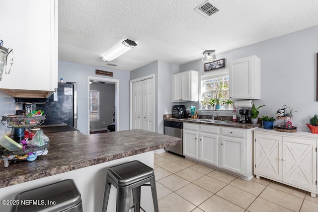 kitchen featuring white cabinets, a textured ceiling, appliances with stainless steel finishes, and sink