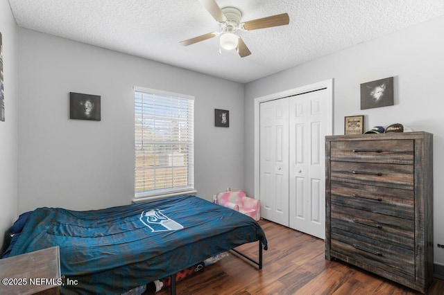 bedroom featuring a textured ceiling, a closet, dark wood-type flooring, and ceiling fan