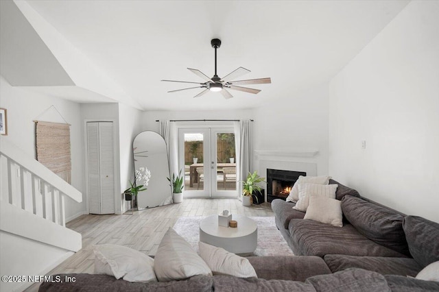 living room featuring french doors, light wood-type flooring, and ceiling fan