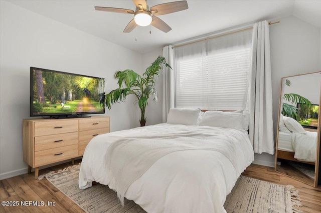 bedroom with vaulted ceiling, ceiling fan, and hardwood / wood-style floors