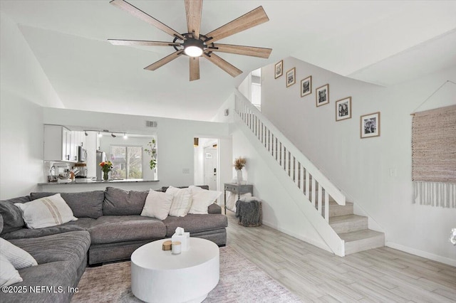 living room featuring high vaulted ceiling, ceiling fan, and light hardwood / wood-style flooring