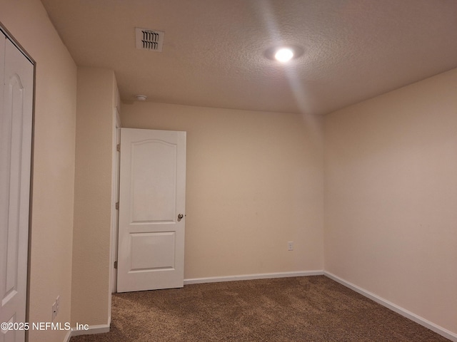 carpeted empty room with a textured ceiling