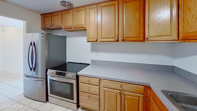 kitchen with light tile patterned flooring and appliances with stainless steel finishes