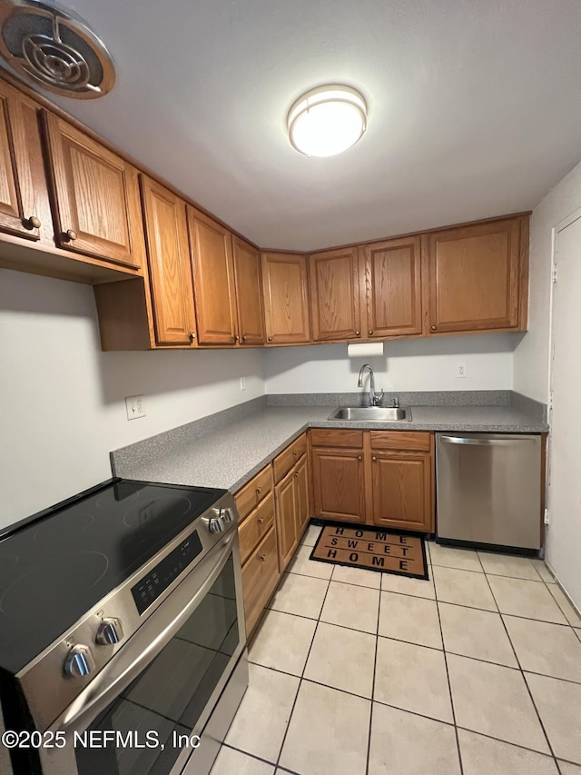 kitchen with sink, light tile patterned floors, and appliances with stainless steel finishes