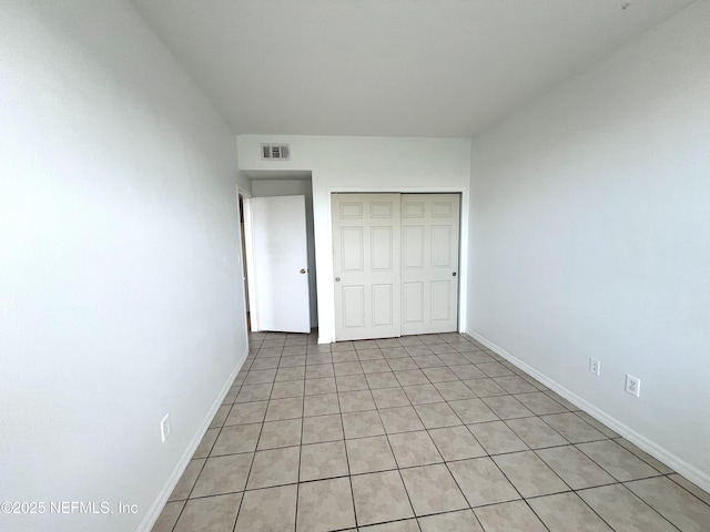 unfurnished bedroom with a closet and light tile patterned floors