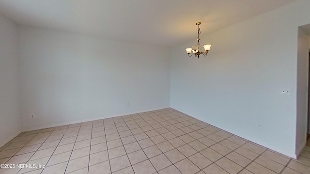 spare room featuring an inviting chandelier and light tile patterned floors