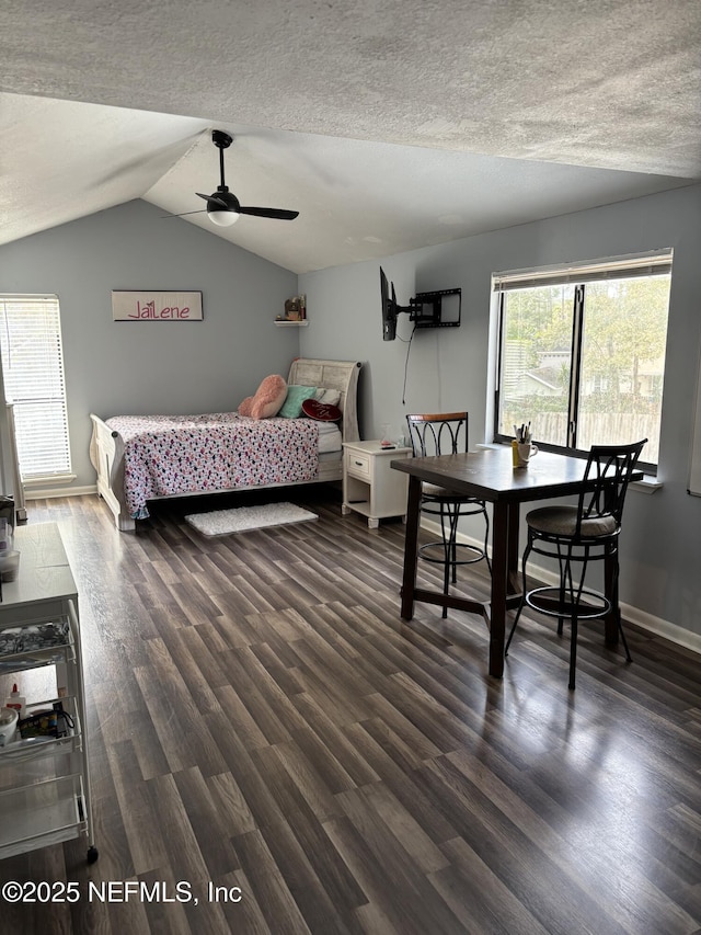 bedroom featuring lofted ceiling, ceiling fan, dark wood-type flooring, and a textured ceiling