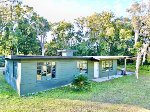 back of house featuring a patio and a lawn