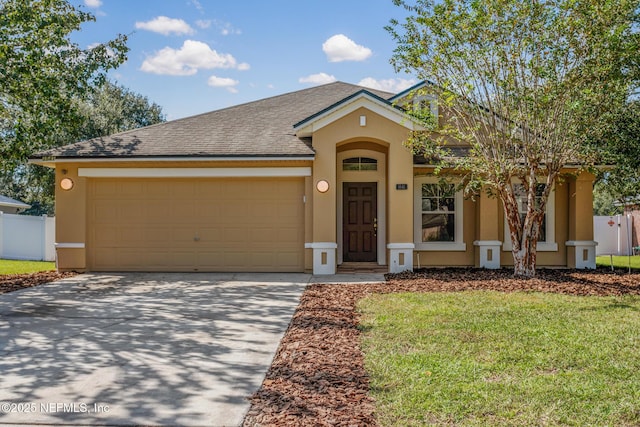 view of front of home featuring an attached garage, fence, concrete driveway, and stucco siding