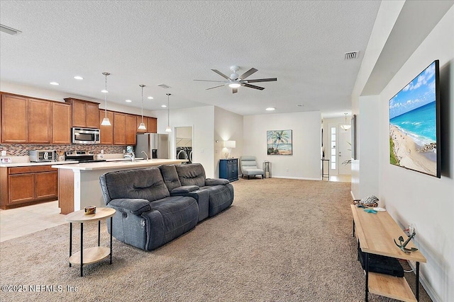 carpeted living room with a textured ceiling and ceiling fan