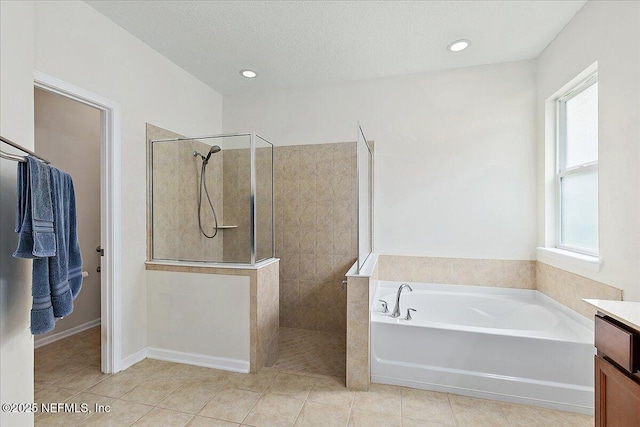 bathroom featuring independent shower and bath, tile patterned flooring, a textured ceiling, and vanity