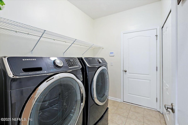 laundry area with washer and clothes dryer and light tile patterned floors