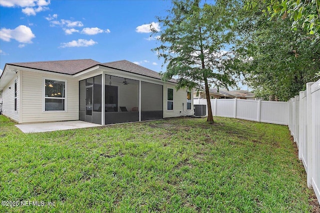 rear view of house featuring a patio, central air condition unit, a sunroom, and a yard