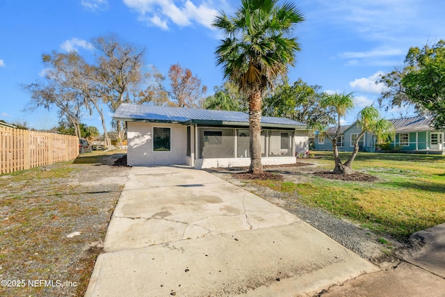 back of property with a sunroom and a yard