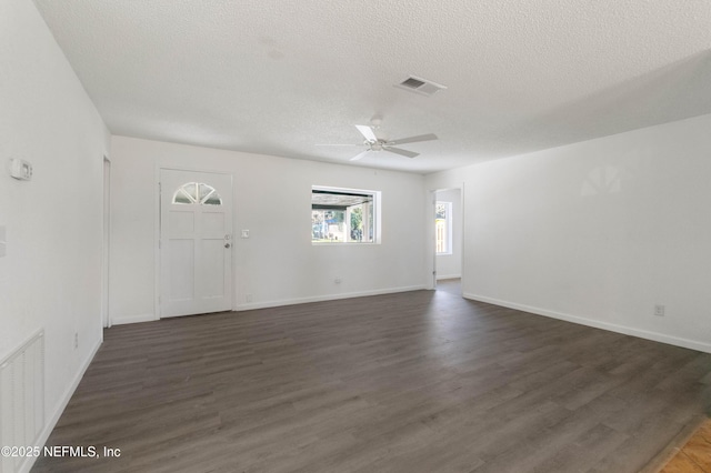 interior space with ceiling fan, dark hardwood / wood-style floors, and a textured ceiling