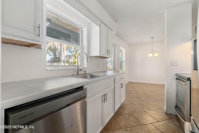 kitchen featuring white cabinetry, stainless steel appliances, decorative light fixtures, and sink