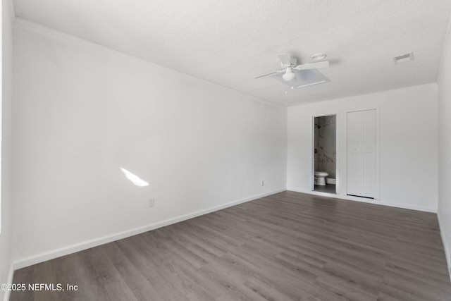 spare room featuring a textured ceiling and dark hardwood / wood-style flooring