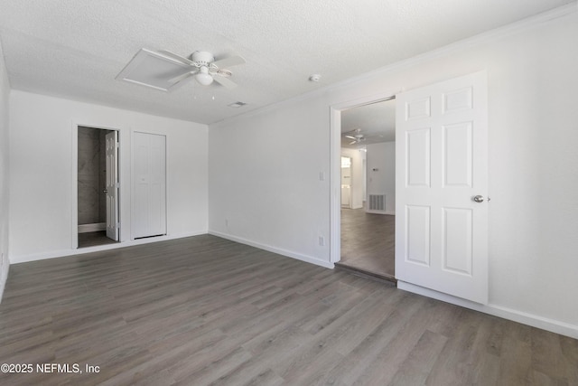 empty room with ceiling fan, dark wood-type flooring, and a textured ceiling