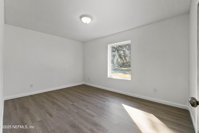 unfurnished room with wood-type flooring and a textured ceiling