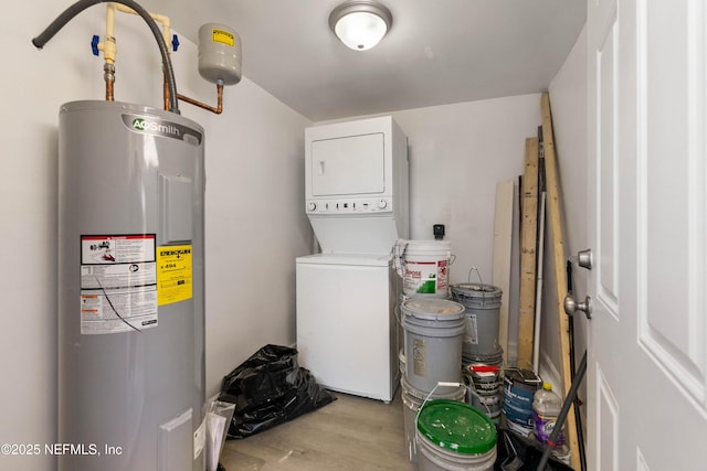 clothes washing area with stacked washing maching and dryer and water heater