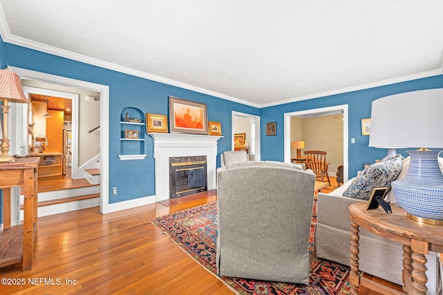 living room with hardwood / wood-style floors, ornamental molding, and a premium fireplace