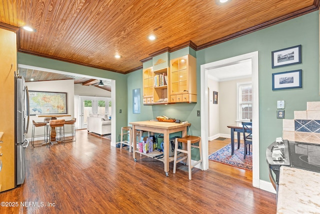 kitchen with lofted ceiling with beams, ornamental molding, stainless steel appliances, dark wood-type flooring, and french doors