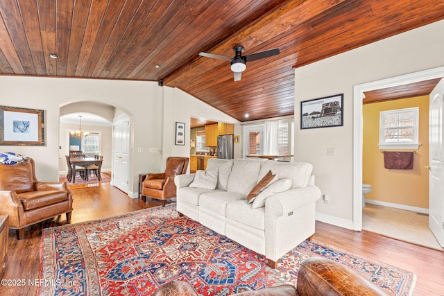 living room featuring hardwood / wood-style flooring, vaulted ceiling with beams, ceiling fan with notable chandelier, and wood ceiling