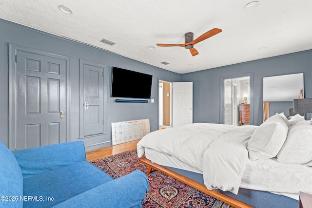 bedroom featuring hardwood / wood-style flooring, ceiling fan, and ensuite bathroom