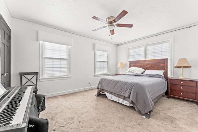 bedroom featuring crown molding, light colored carpet, a textured ceiling, and ceiling fan