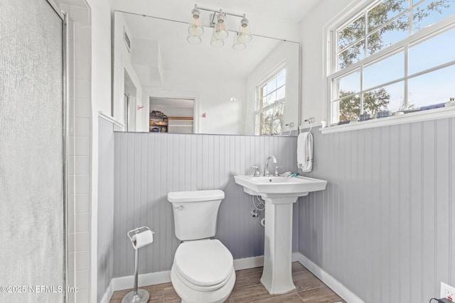 bathroom with toilet, an enclosed shower, and sink